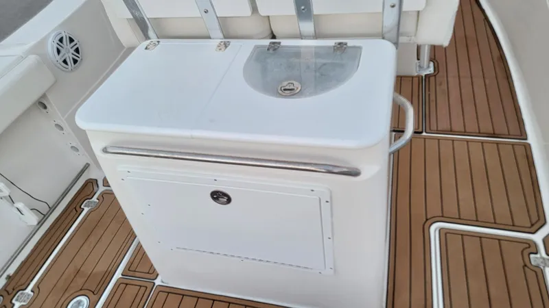Slide: The Image of 2010 Sea Fox 286 Commander boat interior with sink and storage on teak flooring. - 9