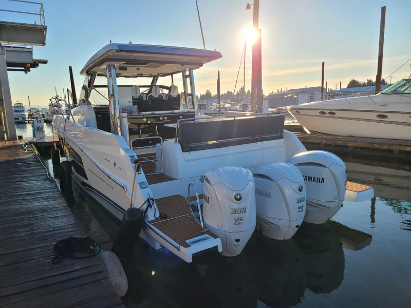 Slide: The Image of 2021 Jeanneau Leader 12.5 boat docked with triple Yamaha engines at sunset. - 2