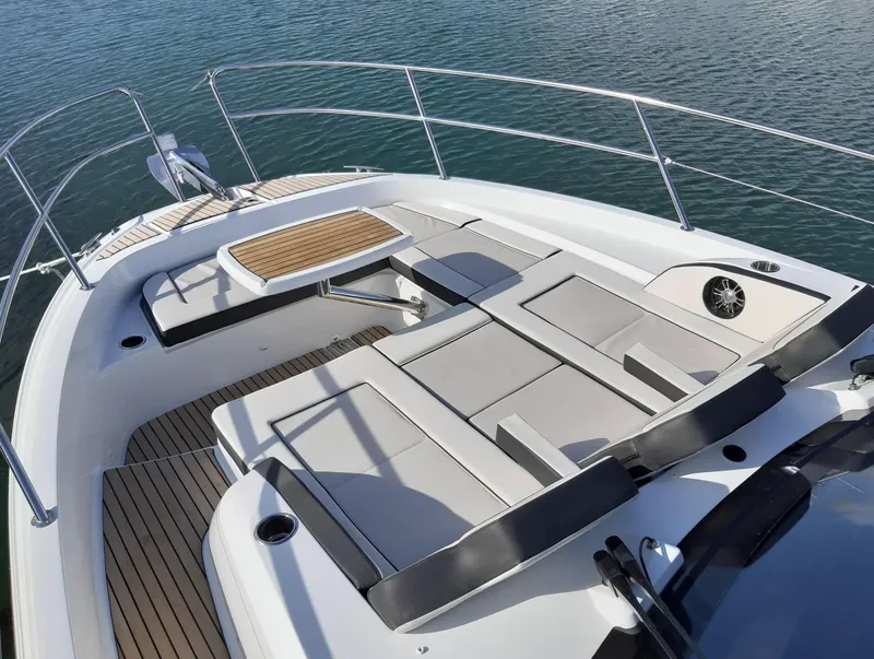 Slide: The Image of 2021 Jeanneau Leader 12.5 boat deck with cushioned seating and table. - 6