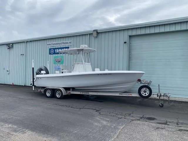 Slide: The Image of 2015 Contender 24 Sport boat on trailer outside a warehouse. - 1