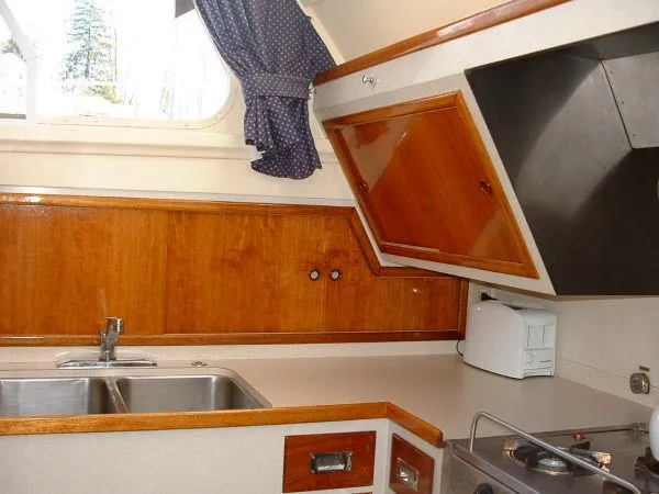 Slide: The Image of 1972 Huckins Atlantic 50 yacht kitchen with wooden cabinets and stainless steel sink. - 10