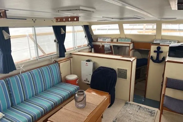 Slide: The Image of 1972 Huckins Atlantic 50 yacht interior with striped seating and nautical decor. - 5