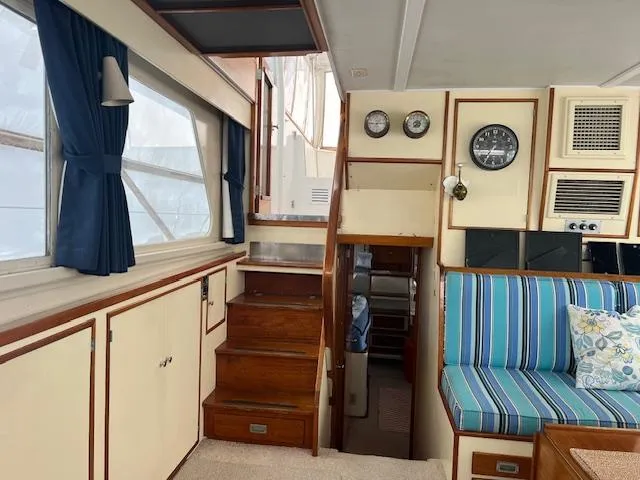 Slide: The Image of Interior of 1972 Huckins Atlantic 50 yacht with wooden stairs and blue-striped seating. - 4