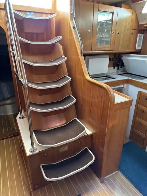 Slide: The Image of Interior of 2009 Catalina 470 yacht with wooden stairs and compact kitchen area. - 37