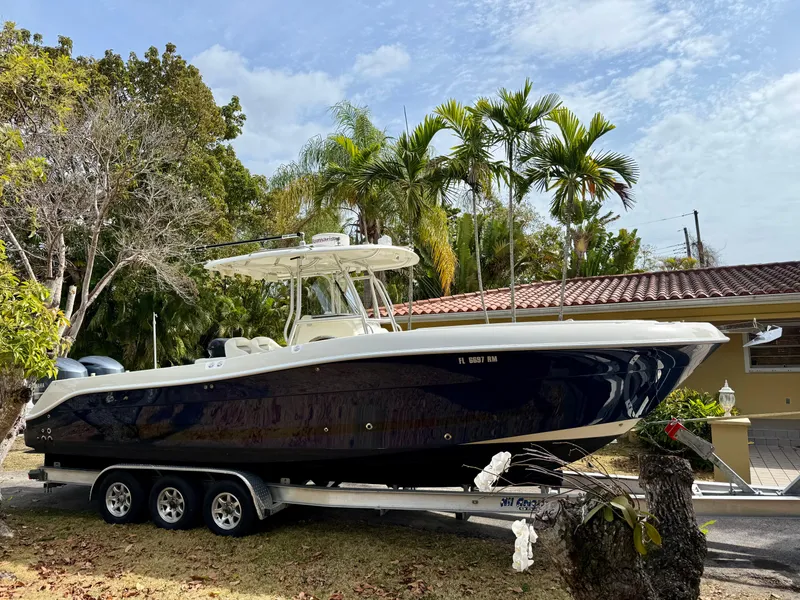 Slide: The Image of 2008 Hydra-Sports Vector 2900 CC boat on trailer, parked near tropical trees. - 0
