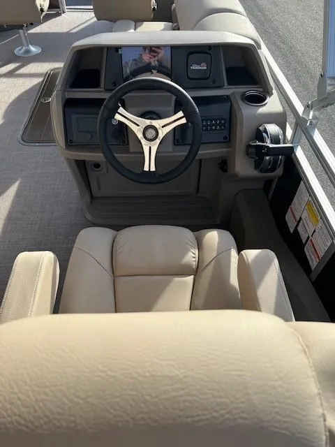 Slide: The Image of 2024 Sun Tracker Sportfish 24 XP3 boat helm with beige seating and modern controls. - 13