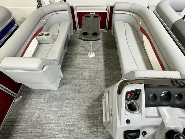 Slide: The Image of 2024 Bennington 20 SSR pontoon boat interior with gray and red seating, table, and control panel. - 7