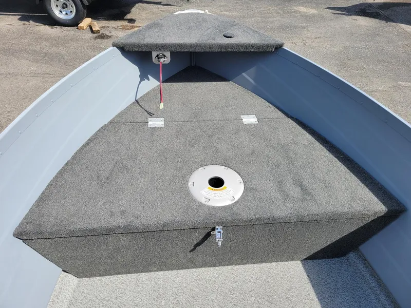 Slide: The Image of 2024 Smoker Craft 16 Big Fisherman DLX tiller boat interior, featuring carpeted deck and storage. - 10