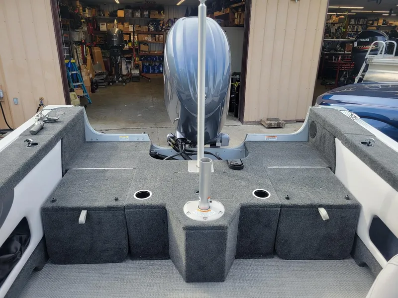 Slide: The Image of 2024 Smoker Craft Ultima Legacy 172 boat interior with Yamaha 150 engine in a workshop. - 22