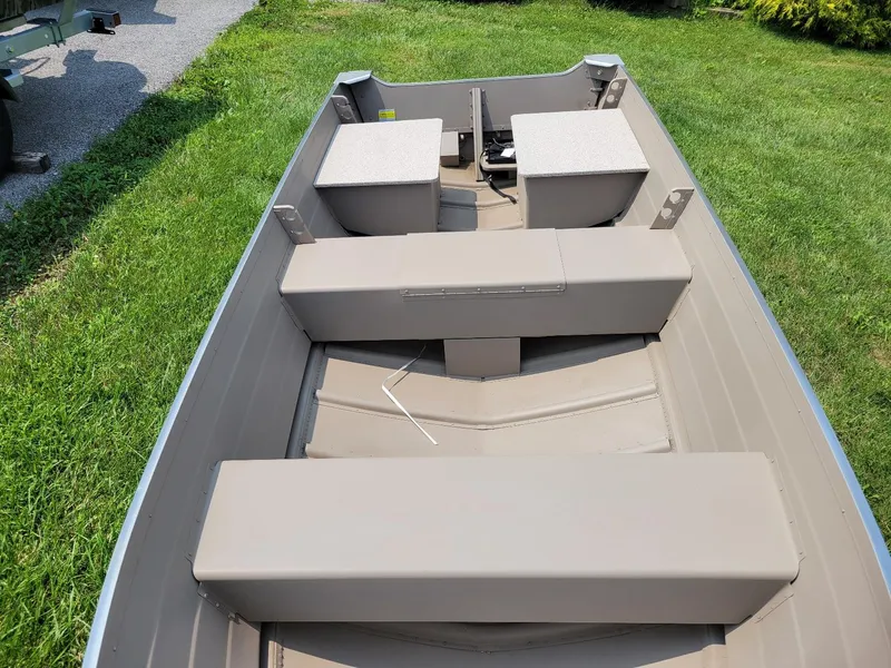 Slide: The Image of 2025 Smoker Craft 16 Voyager tiller boat, beige interior, on grass. - 8