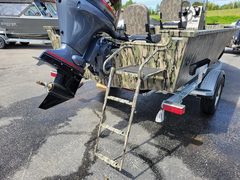 Slide: The Image of 2024 Smoker Craft Freedom 180 CC center console boat in camo, rear view with motor and ladder. - 14