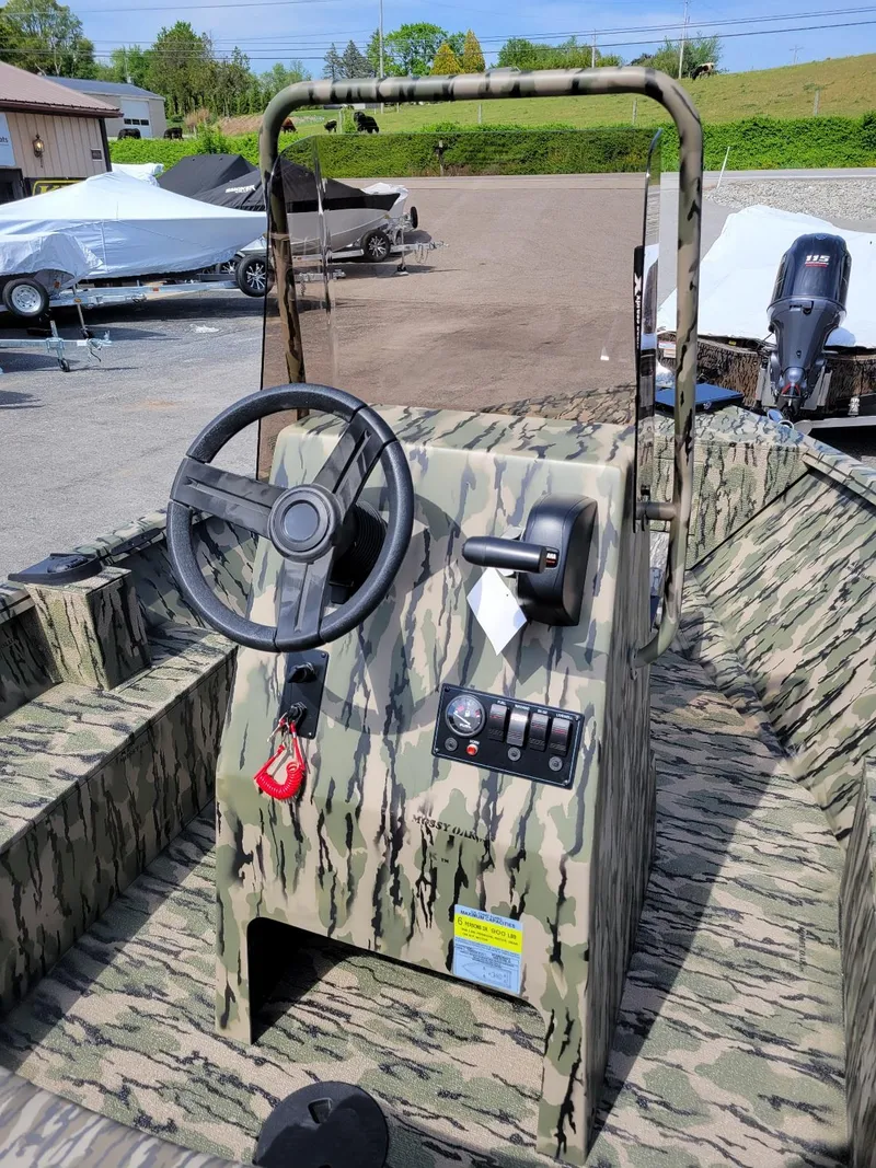 Slide: The Image of 2024 Smoker Craft Freedom 180 CC center console boat in camo, in stock, outdoor display. - 16