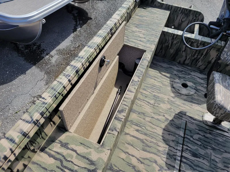 Slide: The Image of 2024 Smoker Craft Freedom 180 CC center console boat, camo design, open storage compartment. - 21