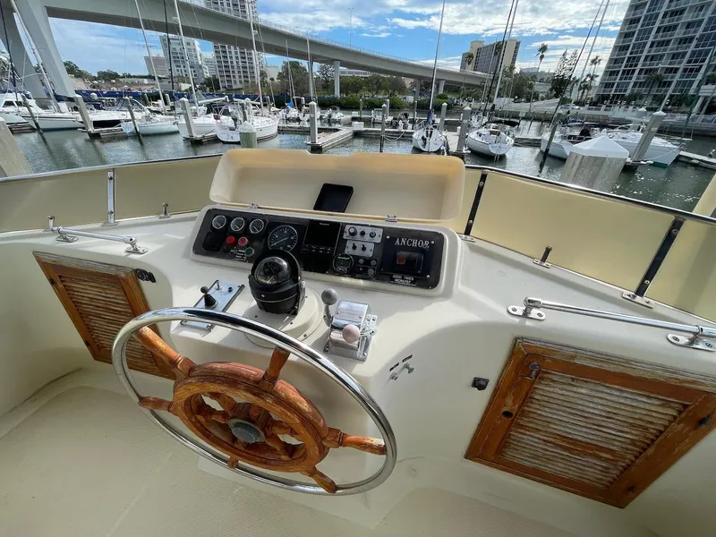Slide: The Image of 1988 Kha Shing 40 Sundeck yacht helm with wooden steering wheel, docked at marina. - 12