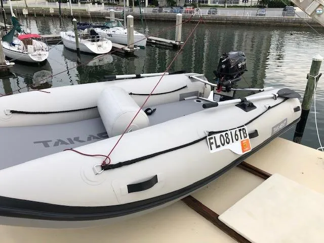 Slide: The Image of Inflatable boat docked at marina with other boats in background. - 15