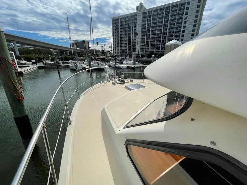 Slide: The Image of 1988 Kha Shing 40 Sundeck yacht docked at marina with cityscape background. - 19