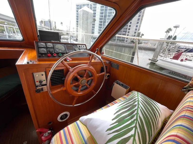 Slide: The Image of 1988 Kha Shing 40 Sundeck yacht interior with wooden steering wheel and colorful seating. - 21