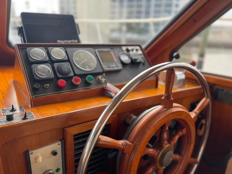 Slide: The Image of 1988 Kha Shing 40 Sundeck yacht helm with wooden steering wheel and control panel. - 22