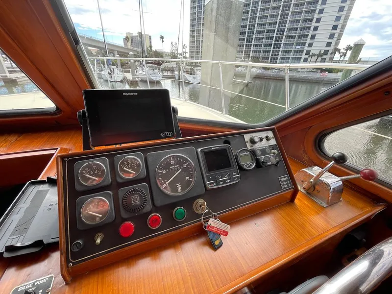 Slide: The Image of 1988 Kha Shing 40 Sundeck boat helm with gauges and controls at marina. - 23