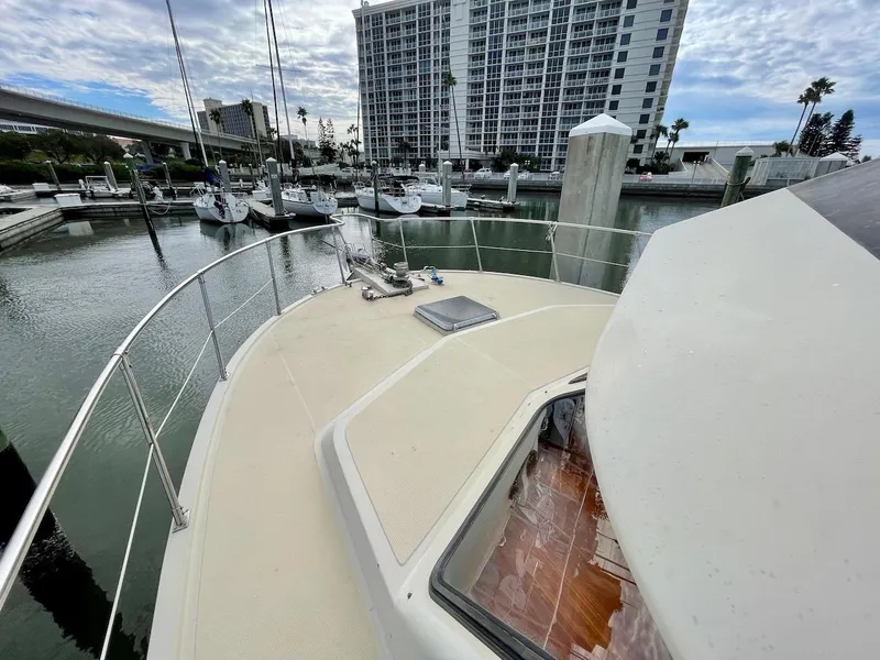 Slide: The Image of 1988 Kha Shing 40 Sundeck yacht docked at a marina with cityscape background. - 3