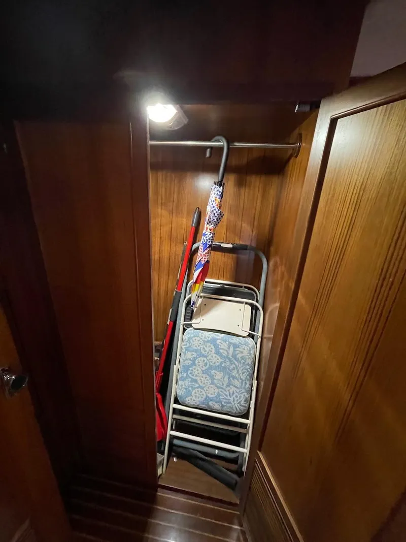 Slide: The Image of 1988 Kha Shing 40 Sundeck yacht interior storage closet with folding chairs and cleaning tools. - 37