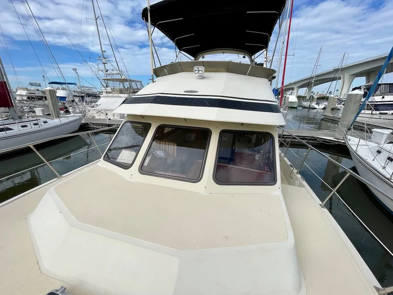 Slide: The Image of 1988 Kha Shing 40 Sundeck yacht docked at marina with bridge in background. - 5