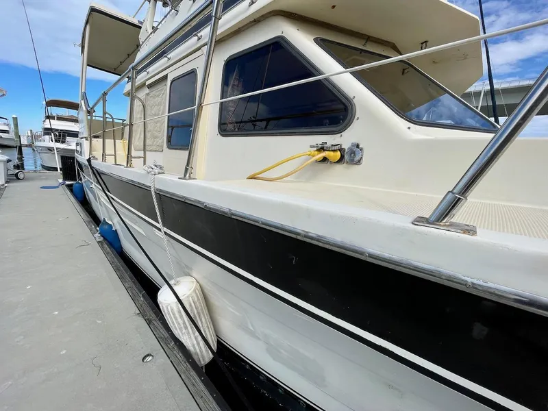 Slide: The Image of 1988 Kha Shing 40 Sundeck yacht docked at marina, side view. - 6