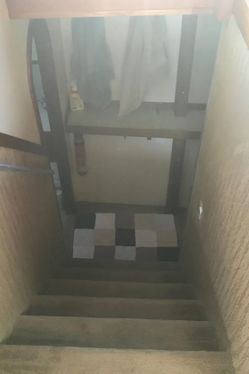 Slide: The Image of Staircase inside 2008 Custom 62 Catamaran with patterned rug and wooden walls. - 12