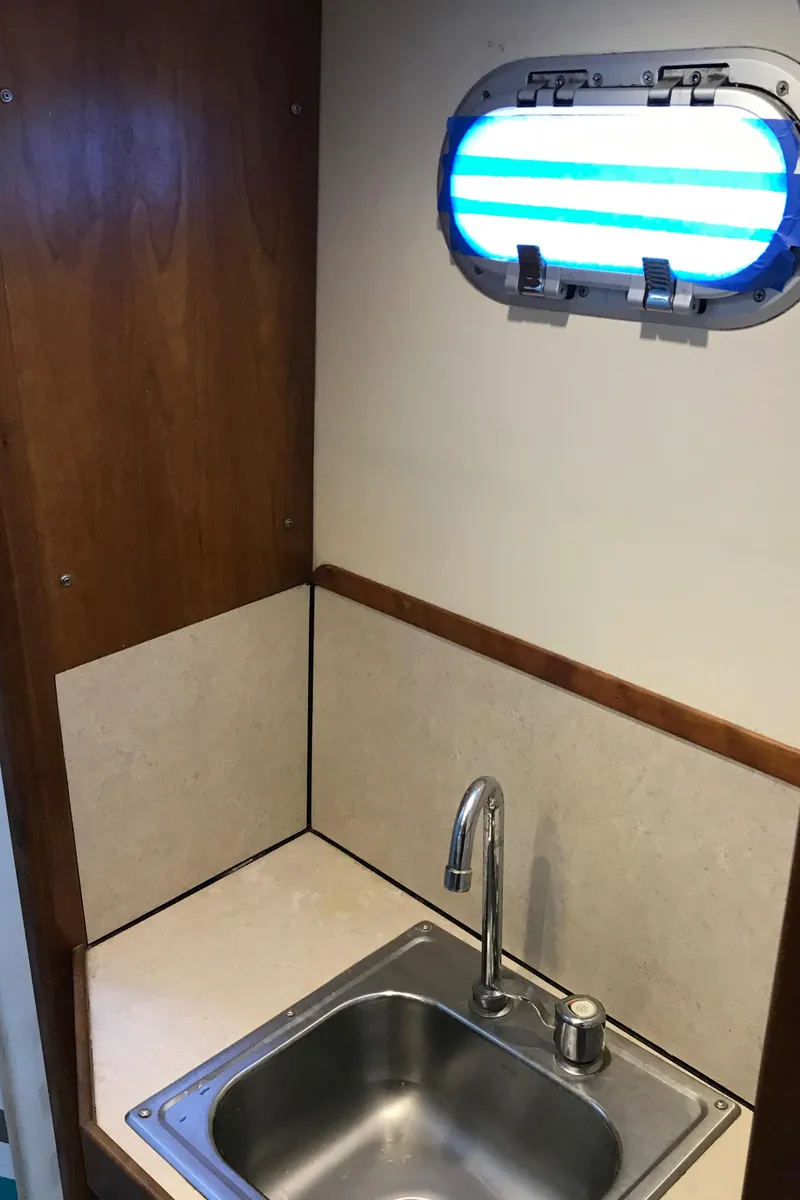 Slide: The Image of Small sink area with porthole window on a 2008 Custom 62 Catamaran. - 15