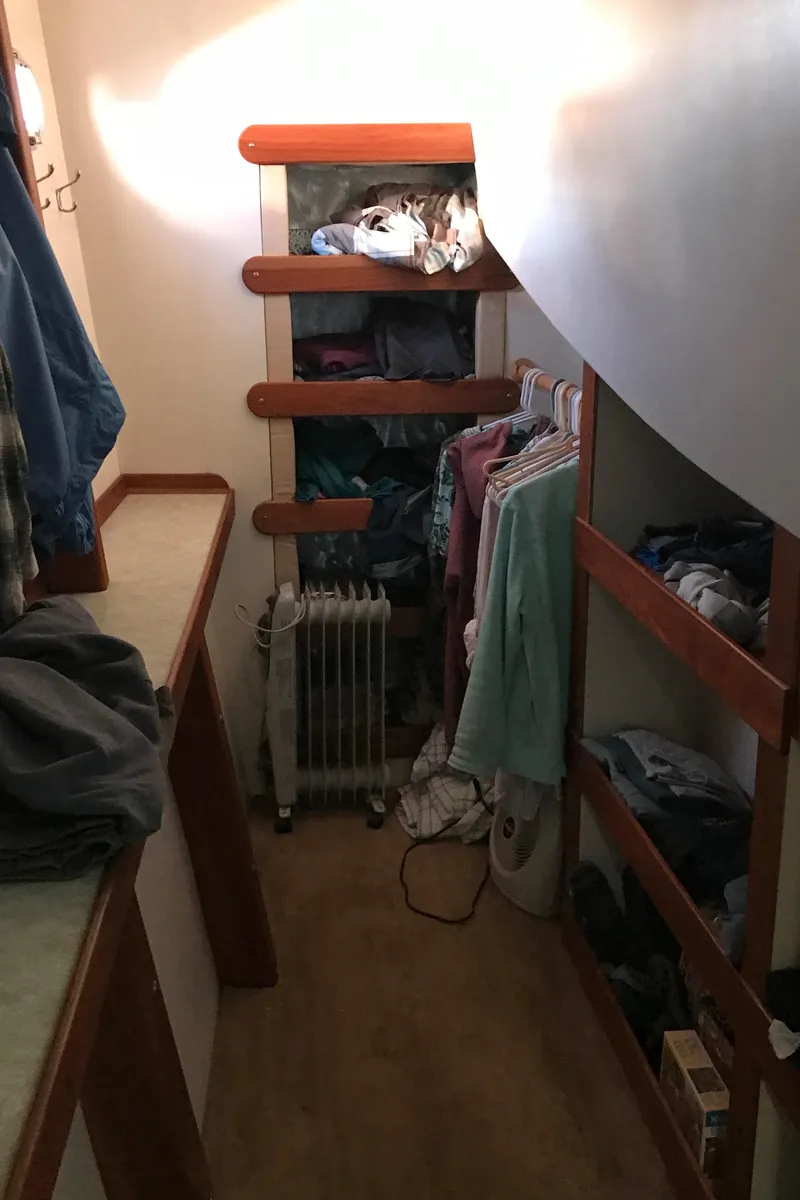 Slide: The Image of Narrow closet space on a 2008 Custom 62 Catamaran with clothes and shelves. - 17