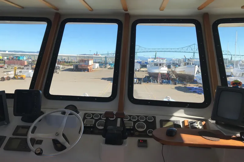 Slide: The Image of Interior view of a 2008 Custom 62 Catamaran cockpit with marina in background. - 26