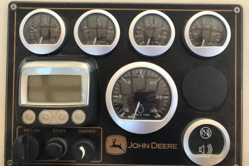 Slide: The Image of Instrument panel with gauges and controls on a 2008 Custom 62 Catamaran, featuring John Deere branding. - 28