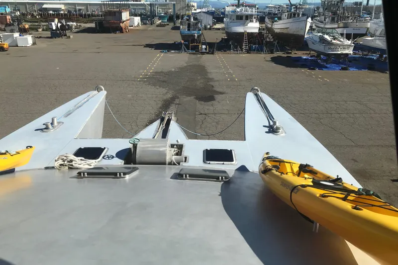 Slide: The Image of Custom 62 Catamaran (2008) on dry dock with yellow kayaks on deck. - 29