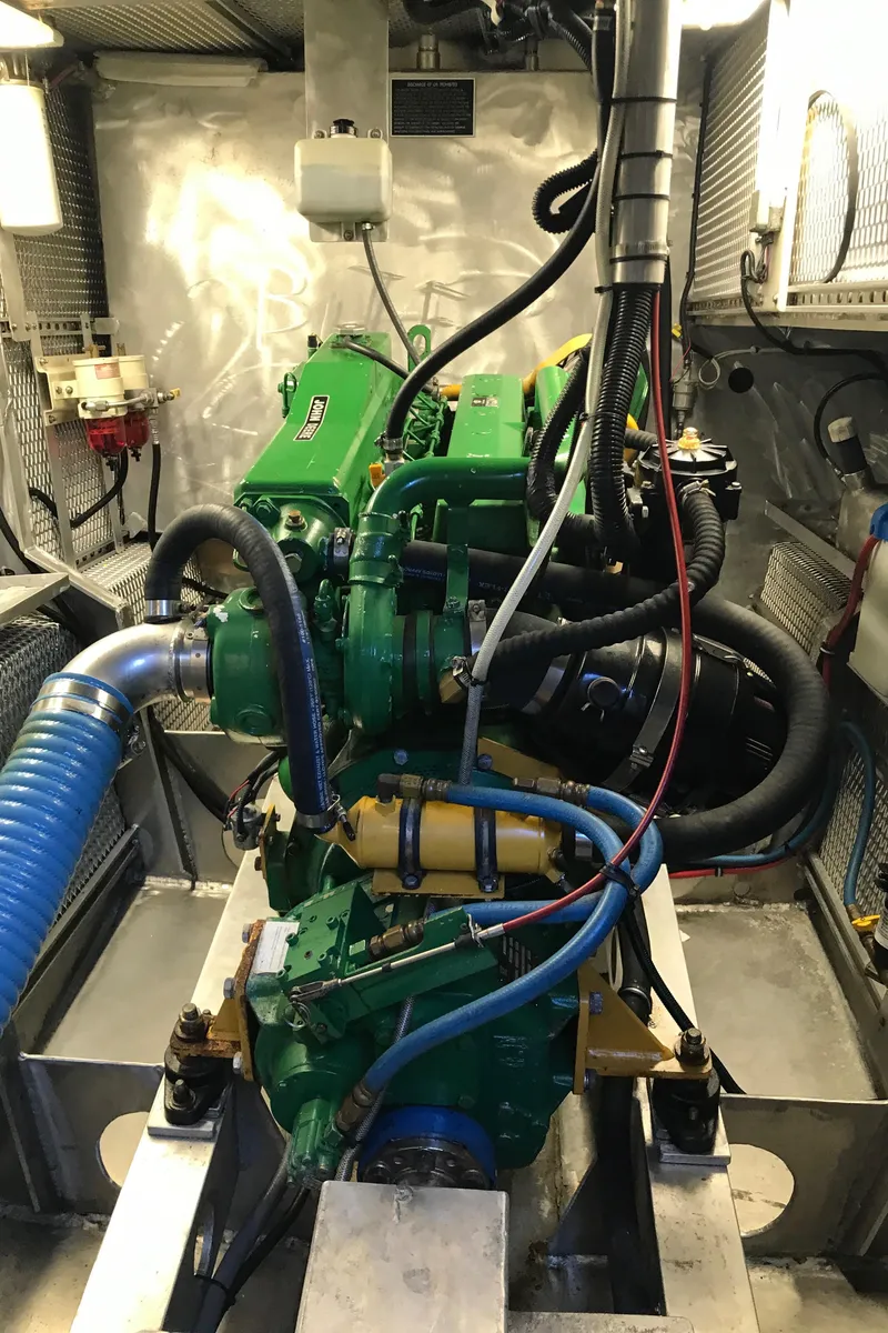 Slide: The Image of Engine room of a 2008 Custom 62 Catamaran with visible green engine components. - 34