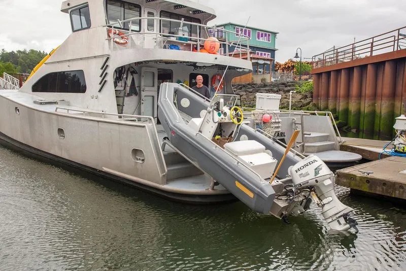 Slide: The Image of Custom 62 Catamaran (2008) docked with inflatable boat and Honda outboard motor. - 36