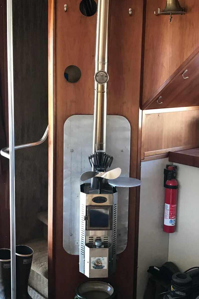 Slide: The Image of Wood-paneled interior of a 2008 Custom 62 Catamaran with a mounted heater and fire extinguisher. - 4