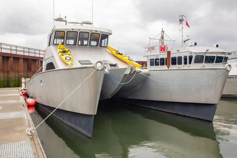 Slide: The Image of Custom 62 Catamaran, 2008 model, docked alongside another vessel in a marina. - 40