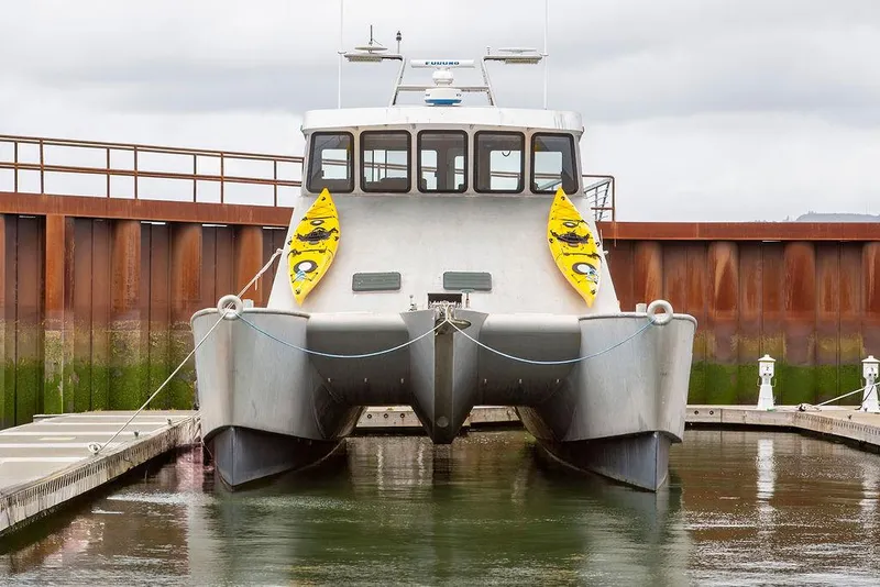 Slide: The Image of Custom 62 Catamaran, 2008 model, docked with kayaks attached, in a marina setting. - 41