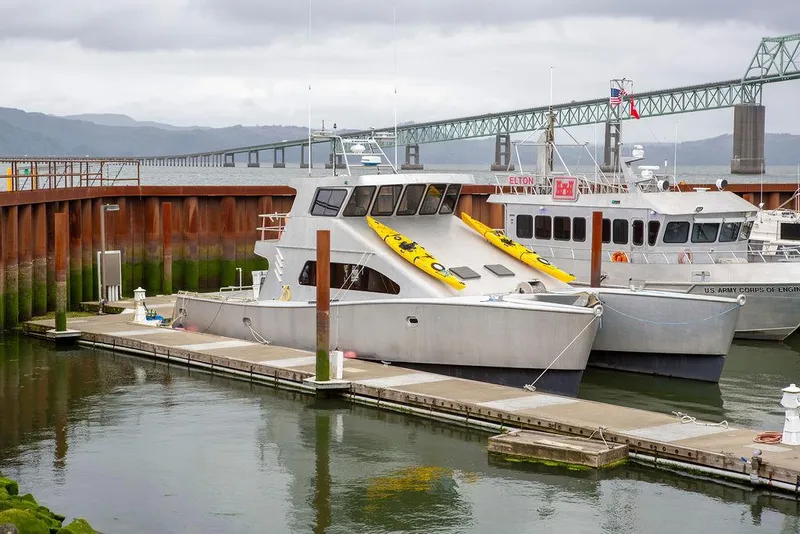 Slide: The Image of Custom 62 Catamaran 2008 docked at marina with bridge in background. - 42
