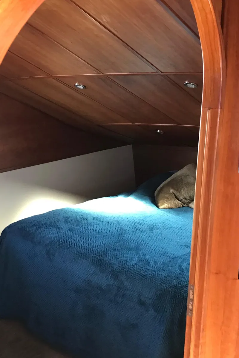 Slide: The Image of Cozy cabin interior of 2008 Custom 62 Catamaran with wooden finish and blue bedding. - 9