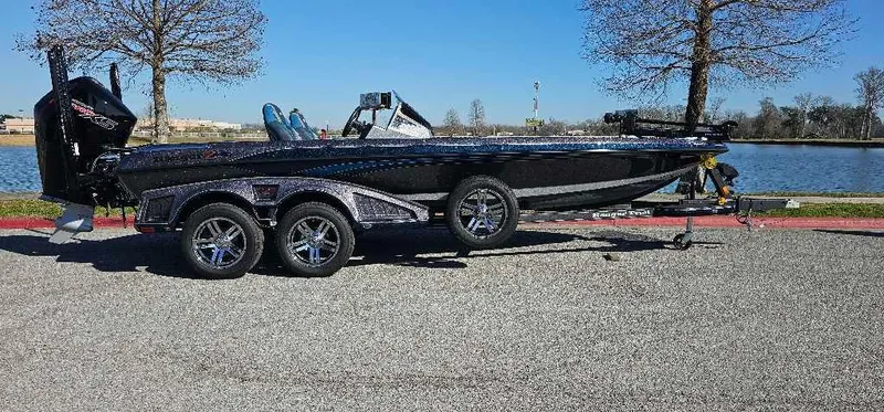 Slide: The Image of 2024 Ranger Z521R Ranger Cup Equipped boat on trailer by a lake. - 1