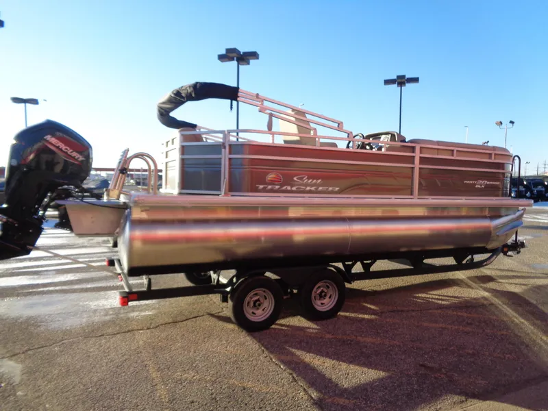 Slide: The Image of 2024 Sun Tracker Party Barge 20 DLX pontoon boat on trailer in parking lot. - 3