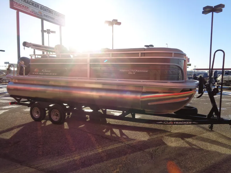 Slide: The Image of 2024 Sun Tracker Party Barge 20 DLX pontoon boat on a trailer at a dealership. - 5