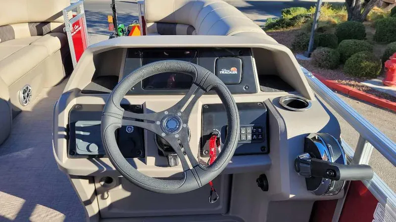 Slide: The Image of 2024 Sun Tracker Party Barge 20 DLX steering console with modern controls and comfortable seating. - 5