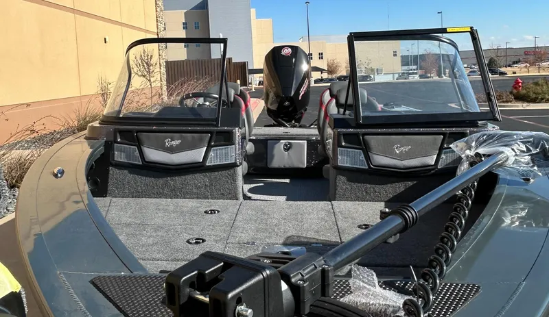 Slide: The Image of 2024 Ranger VX1888 WT fishing boat with dual consoles and motor, parked outdoors. - 2