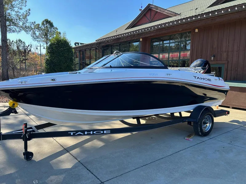 Slide: The Image of 2024 Tahoe 200 S boat on trailer outside a wooden building. - 3