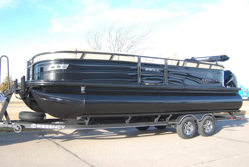 Slide: The Image of 2024 Regency 230 LE3 pontoon boat on a trailer. - 0