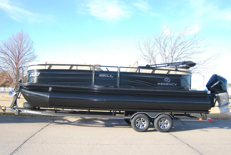 Slide: The Image of 2024 Regency 230 LE3 pontoon boat on a trailer. - 1