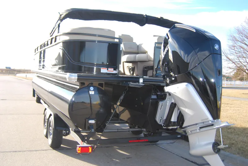 Slide: The Image of 2024 Regency 230 LE3 pontoon boat with powerful outboard motor on trailer. - 2