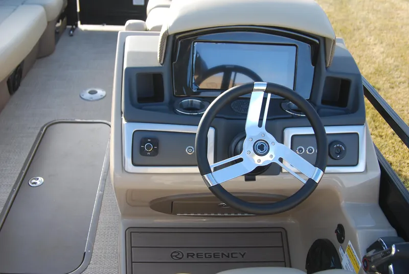 Slide: The Image of 2024 Regency 230 LE3 boat dashboard with steering wheel and control panel. - 4